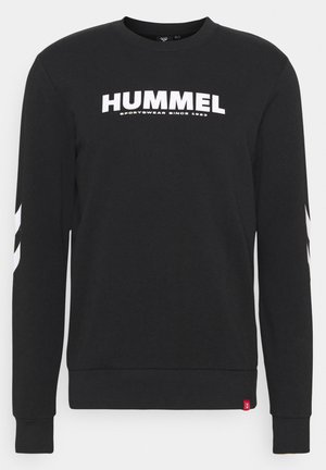 Svart crewneck genser med hvit "HUMMEL" tekst og logo, samt striper på ermene og ribbestrikkede mansjetter og kant.