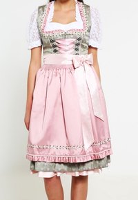 Traditional dirndl dress featuring a green bodice with lace trim, pink skirt with polka dots, and ribbon accents. Ruffled hem and bow detail.