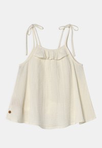 Top sin mangas de color crema claro con tirantes ajustables, tejido texturizado y detalle de volantes en el frente. Presenta un botón decorativo en el costado.
