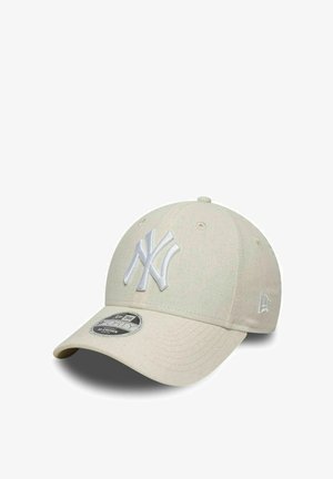 Beige New York Yankees baseball cap with curved brim and embroidered team logo on front, shown against white background.