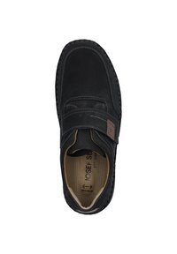Scarpa in pelle nera con cinturino in Velcro, punta arrotondata e suola testurizzata. L'interno presenta un'imbottitura a pois per il comfort.