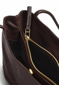 Borsa a mano in pelle marrone scuro con cerniera e chiusura dorate, che mostra gli scomparti interni e i manici.