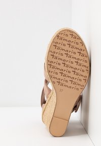 Sandale espadrille avec tige textile marron et talon compensé recouvert de jute. La semelle présente le logo "Tamaris" et l'inscription taille 37.