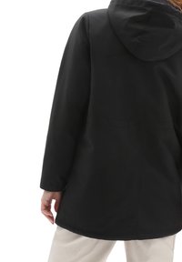 Zwarte hoodie met een gladde, matte afwerking. Heeft een losse pasvorm, lange mouwen en minimale stikseldetails aan de achterkant.