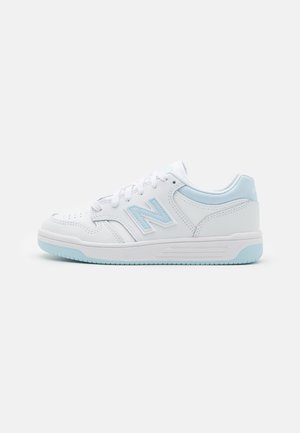 Baskets basses blanches avec des accents bleu clair, avec un logo "N" cousu sur le côté et une semelle bleu clair, montrées en profil latéral.