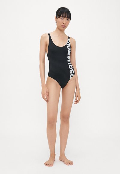 Czarny jednoczęściowy strój kąpielowy o prążkowanej strukturze, średnie ramiączka i odważne, białe logo "DSQUARED2" po lewej stronie. Minimalistyczny design.