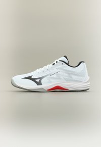 Λευκό αθλητικό παπούτσι με μαύρο λογότυπο, κόκκινο τόνο στη σόλα και κείμενο "LIGHTNING STAR Jr", απεικονισμένο σε προφίλ πλευράς σε ουδέτερο φόντο.