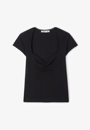 Czarny prążkowany top z krótkim rękawem, kwadratowym dekoltem, koronkową lamówką i marszczeniem na środku z przodu. Etykieta rozmiaru widoczna wewnątrz kołnierza.