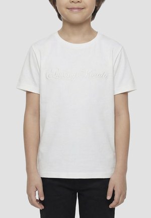 Enfant portant un t-shirt blanc uni à manches courtes avec un texte discret "Antony Morato" et un pantalon noir, debout devant un fond uni.