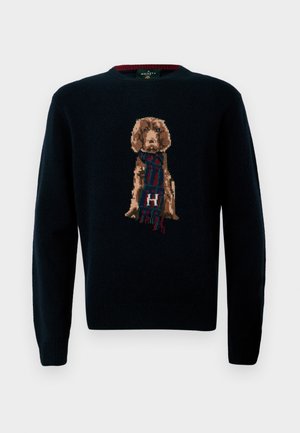 Tamsiai mėlynas megztinis su detaliu šunų dizainu, nešiojančiu šalį. Minkšta tekstūra, apvali iškirptė ir räfiniai rankogaliai bei kraštai.