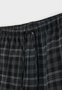 Mustavihreät ja harmaat ruudulliset shortsit, joissa on joustava vyötärönauha ja kiristysnyöri. Valmistettu kevyestä, pehmeäpintaisesta kankaasta.