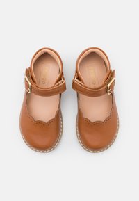 Brązowe skórzane buty Mary Jane z falbaniastymi krawędziami, pasek z złotą klamrą oraz jasnoróżowym wnętrzem. Gumowe podeszwy z detalami w formie stichew.