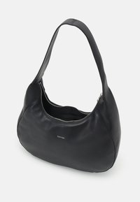Sac hobo en cuir noir avec une texture lisse, une forme incurvée, un zip en haut et une seule bandoulière. Présente un détail de logo subtil.