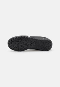 Suola di scarpa atletica nera con battistrada in gomma testurizzata, caratterizzata da un motivo di presa distintivo e un design minimalista. Nessun logo visibile.