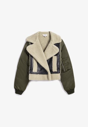 Kort jasje met een schapenbont kraag, olijfgroene mouwen en zwarte nep leren accenten. Heeft een heteluchtzakje op de linkerarm.