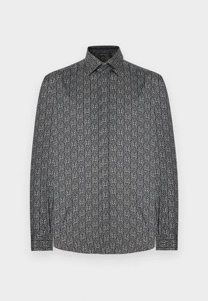 Camisa de manga larga con base gris oscuro y un patrón abstracto blanco repetitivo. Cuello abotonado y detalles de los puños visibles.