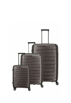 Three dark gray hard-shell suitcases in small, medium, and large sizes, each with four wheels and extended telescopic handles.