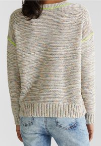 Lättstickad tröja i flerfärgat garn, med ribbad nederkant och ärmslut. Kontrastverk i neongrön på axlarna.