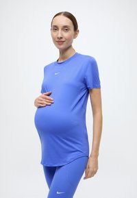 Σετ μπλε αθλητικό t-shirt και κολάν, κατασκευασμένο από ελαστικό ύφασμα, με κοντά μανίκια και στρογγυλή λαιμόκοψη, με μικρό λογότυπο στο στήθος.