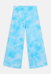 Blue tie-dye wide-leg pants with an elastic waistband and a small pink "GAP" logo on the left side. Made of soft, lightweight material.