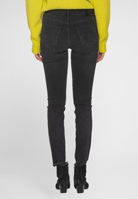 Černé úzké džíny z denimu, s vysokým pasem, zadními kapsami se šitím a elegantním, přiléhavým střihem.