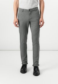 Gray tailored pants made of soft fabric, featuring a flat front, side pockets, and a slim fit design. Paired with black shoes.