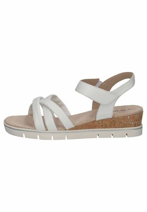White sandal with crossover straps, cork-like wedge heel, textured base, and adjustable ankle strap. Soft footbed with a neutral finish.