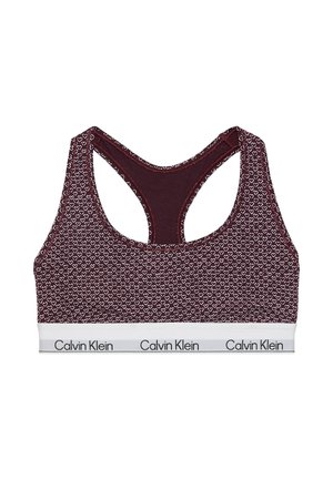 Sujetador deportivo granate con patrón de corazones blancos y banda elástica blanca con el logo "Calvin Klein" en negro alrededor de la parte inferior.