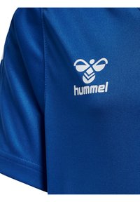 Blå sportströja i ett glatt material, med en vit logotyp av en bi och ordet "hummel" på bröstet. Kortärmad med en klassisk passform.