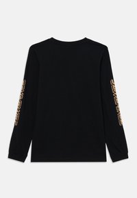 Svart långärmad T-shirt i bomull, med rund halsringning och gyllene grafik längs vänster ärm. Mjuk textur och avslappnad passform.