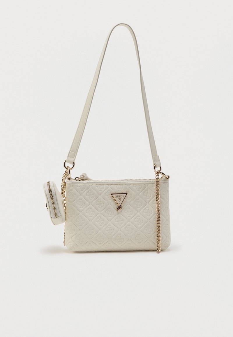 Κρέμ διπλωμένη τσάντα ώμου με αλυσίδα, μικρό προσαρτημένο τσαντάκι με φερμουάρ και τριγωνικό λογότυπο Guess μπροστά.
