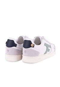 Zapatillas blancas con un acento de gamuza gris y azul marino. Cuentan con un logo verde, correas texturizadas y una suela de goma ligera.