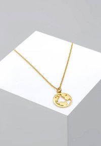Goldene Halskette mit einem runden Anhänger, der ein ausgeschnittenes Design der Weltkarte zeigt. Die Kette ist zart und strukturiert.