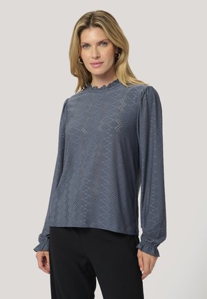Texturierte blaue Bluse mit langen Ärmeln, einer gewellten Ausschnittgestaltung und Puffärmeln. Verfügt über Ausschnittmuster in einem Zickzackdesign.
