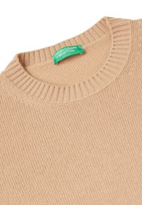 Beige gebreide trui met een geribbelde textuur en ronde halslijn. Heeft een groene label met de tekst "United Colors of Benetton" op de kraag.