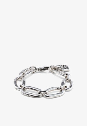 Pulsera de cadena gruesa plateada con eslabones ovalados irregulares y un charm en forma de corazón grabado con "UNO de 50" sobre un fondo blanco.