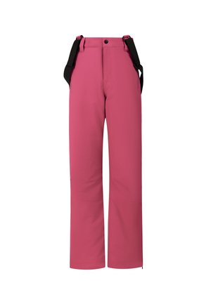 Jonge vrouw draagt een beige fleece, roze sneeuwbroek met zwarte bretels, zwarte sneeuwlaarzen, een roze muts en zwarte skibril op haar hoofd.
