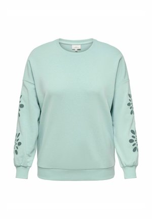 Sweatshirt vert menthe clair en tissu doux. Présente des manches oversized et un imprimé floral graphique sur chaque manche. Design à col rond.