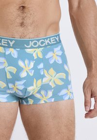 Herrens boxer kalsonger i en teal tyg med ett blommönster med gula och ljusblå accenter; elastisk midjeband med "JOCKEY"-logga.