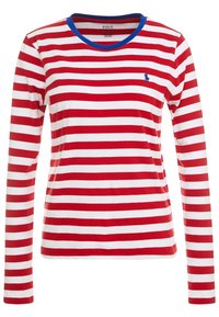 Maglietta a maniche lunghe a righe rosse e bianche con colletto blu a costine e un piccolo logo blu sul petto. Materiale in cotone morbido.