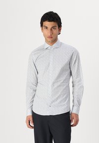 Langsleeve, button-up shirt in het wit met blauw bloemenpatroon, gemaakt van katoen. Kenmerkt zich door een puntige kraag en een getailleerd ontwerp.