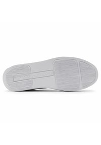 White rubber shoe sole with herringbone pattern, featuring a central logo box embossed with "ARMANI EXCHANGE."