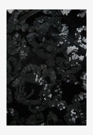 Černá látka zdobená složitými stříbrnými flitry s květinovým vzorem. Textura je hladká s lesklým odrazovým účinkem.