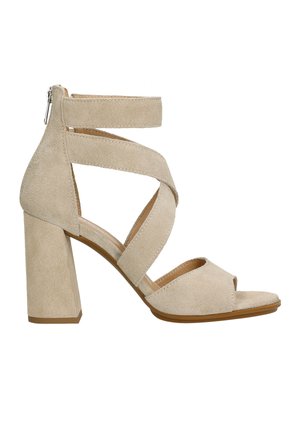 Beige suede high-heeled sandal with a block heel, open toe, and crossed ankle straps. Features a back zipper for easy wear.