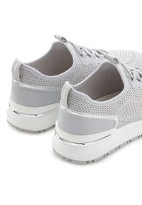 Helle graue Sportschuhe mit einem atmungsaktiven Mesh-Obermaterial, gepolstertem Kragen und metallischen Akzenten an der Ferse. Gummi-Außensohle für besseren Halt.