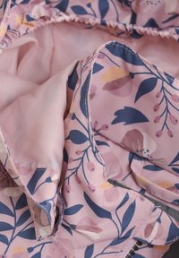 Blomsterpræget stof i nuancer af pink, blå og orange. Blød tekstur med en glat foring, elastisk kant og synlige sømme.