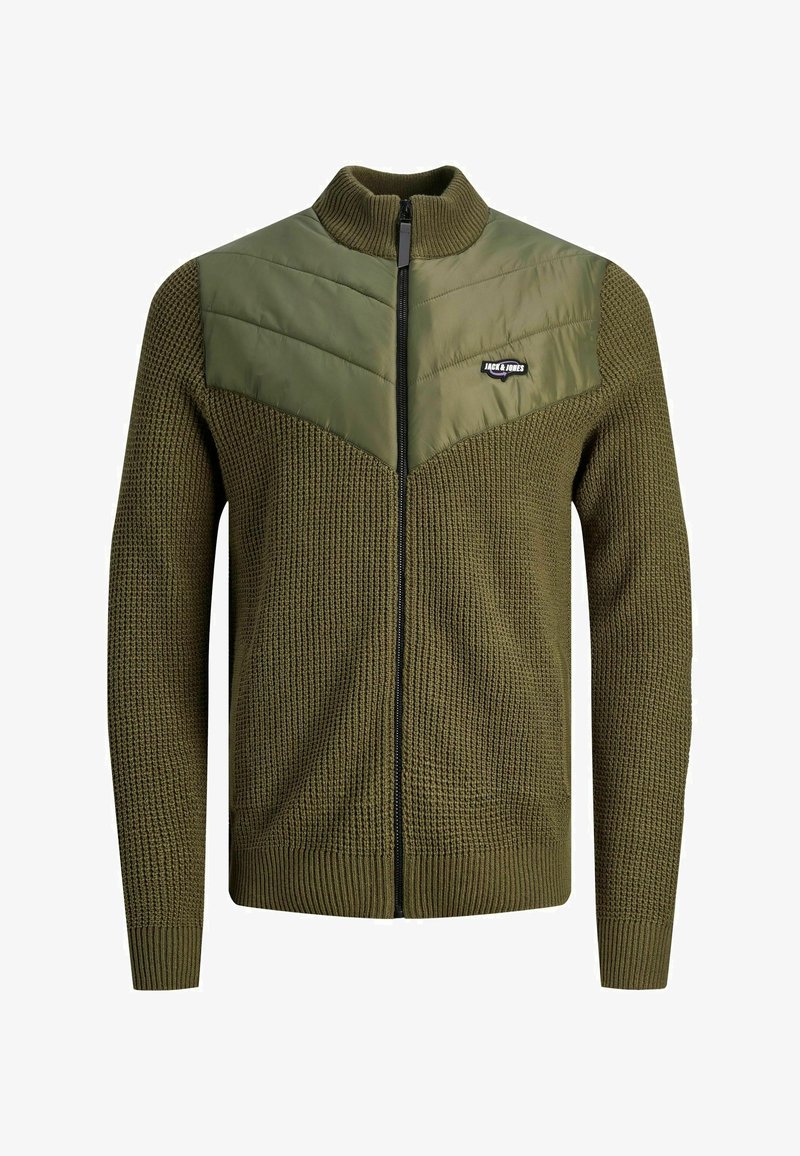 Sudadera de cremallera verde oliva con un cuerpo de punto texturizado y un panel superior acolchado liso. Cuenta con un cuello alto y un parche de la marca en el pecho.