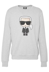 Sudadera gris con una ilustración de un personaje de dibujos animados que lleva gafas de sol, un traje negro y corbata, y una coleta blanca.