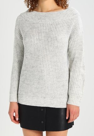 Maglione a maglia grigio chiaro con un ampio scollo a barca, texture a coste e maniche lunghe, abbinato a una mini gonna in pelle nera con bottoni.