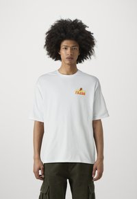 Camiseta blanca de algodón de manga corta con un colorido gráfico "Keep It Fresh" en el lado izquierdo del pecho. Diseño de corte holgado con cuello redondo.